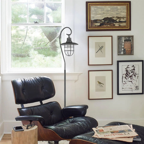 58 Inch Industrial Nautical Floor Lamp With Hanging Cage Shade, Brushed Pewter Finish beside leather chair in living room