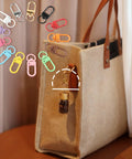 Seventy Eight Piece Small Swivel Snap Lobster Claw Clasps In Assorted Bold Shades attached to a stylish bag for versatile crafting use.