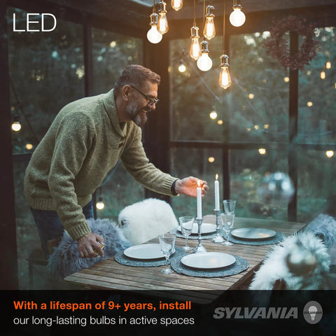 Man setting table under lit G25 Globe LED Light Bulbs 40W Equivalent, Low 3.5W Power Use, Frosted Soft White 2700K