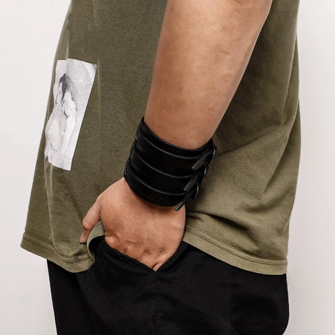 Fresh Hip Hop Drip Wide PU Leather Cuffs For Men adjustable black faux leather band worn on wrist with casual outfit.