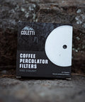 Premium Disc Percolator Coffee Filters For Campers And Home Brewers 3.75 Inch Mesh Paper Filters Pack Of 100 Fits Most Percolators Like Primula Eurolux Mereza And More For Cleaner Tasting Brew packaging on rocks.