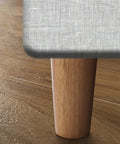 Four Pack Solid Oak Wood Table Legs, Four Inch Tapered Replacement Furniture Feet mounted on a sofa.