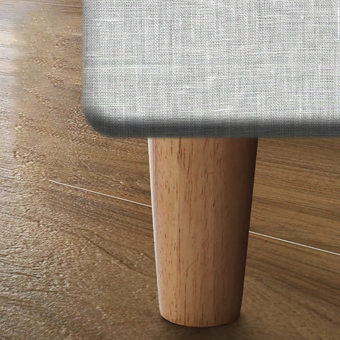 Four Pack Solid Oak Wood Table Legs, Four Inch Tapered Replacement Furniture Feet mounted on a sofa.