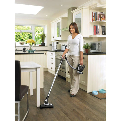 Woman using Dustbuster Flex Cordless Handheld Vacuum For Home Pet And Car Cleaning, 20V Max Battery in kitchen