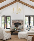 Gold 8 Light Modern Farmhouse Chandelier For Dining Room Kitchen Island Foyer And Living Room Rustic Industrial Candle Pendant Light Fixture With Cupless Candelabra Sockets hanging in living room with vaulted ceiling and beams.