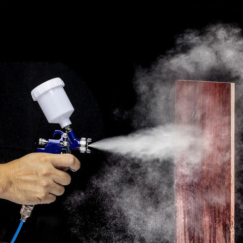 Mini HVLP Gravity Feed Spray Gun With 1.0 Mm Nozzle, 125 CC Cup in use for precise wood painting, demonstrating reduced overspray.