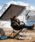 Person sitting in Portable Folding Hammock Camping Chair With Canopy And Footrest, scenic mountain backdrop, windproof feature shown