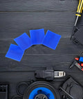 Blue plastic dent puller tabs for Pro-Grade Four-Piece Automotive Dent Removal Kit on black surface