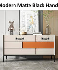 Modern matte black handle installed on a beige and orange cabinet, showcasing the 12 Pack 4 Inch Vintage Barn Door Pulls In Black Metal Screw In Handles For Cabinets And Drawers Heavy Duty Rustic Gate Knobs For Kitchen Furniture And Outdoor Use.
