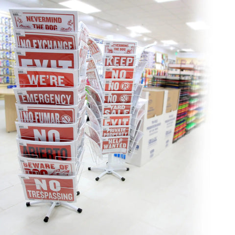 Store aisle with racks displaying red and white sale and warning signs in various languages for retail display