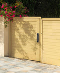 Beige sliding gate with a black handle installed on a sunny day.