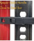 Rugged Black Hi-Lift Jack Handle Keeper For Farm Jacks holding handle close to steel bar, showcasing secure fit and durable design.