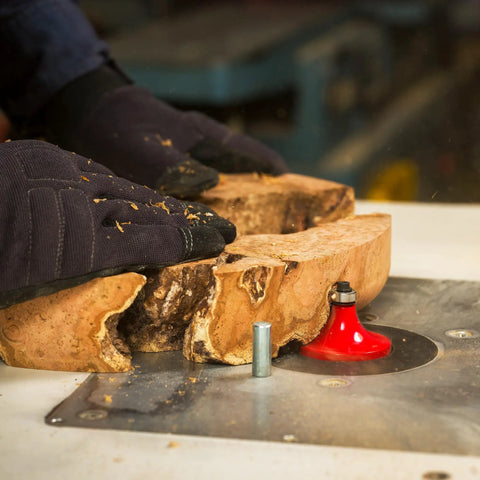 Three Quarter Inch Radius Rounding Over Router Bit With Quadra-Cut Design in use on raw wood in workshop setting.