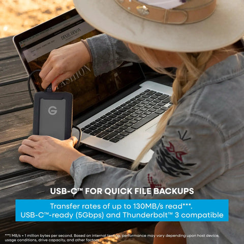Person using G Drive ArmorATD 5TB Rugged Portable External Hard Drive USB C 5Gbps USB 3.2 Gen 1 with laptop outdoors