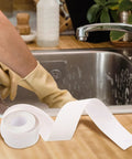Super Easy White PVC Caulking Tape For Bathtub And Window Gaps Peels Sticks And Seals To Stop Water Leaks Without Messy Tools on kitchen counter.