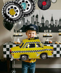 Child holding taxi balloon with Route 66 Retro Party Balloons Kit with Vintage Car Tire Decor and Vinyl Record Foil Balloons.