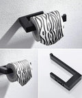 Matte black toilet paper holder from the Dope Matte Black 4-Piece Bathroom Hardware Set with a mounted roll on white wall.