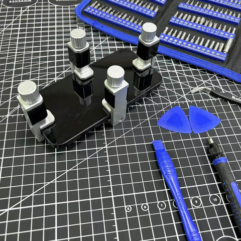 Adjustable Screen Repair Clamps Kit For Phones And Tablets, Universal Clip Fixtures securing a phone screen on a grid mat with tools
