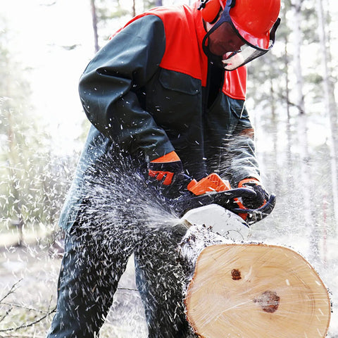 Person using chainsaw on tree trunk wearing Pro Grade Chainsaw Gloves For Full Hand Protection With Cut Resistant Tech EN ISO 11393 4 Class 1 EN 388 4122X CAT III Module B And Module C2 Solid Grip Comfort And All Weather Versatility For Safer Cutting On The Job.