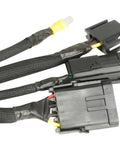 Black automotive wire harness with connectors, cables, and protective sleeving, showing Quick Fix Tape 1 Inch By 12 Foot Self Curing Waterproof Silicone Insulation Tape For Extreme Temperatures And Easy Multi Use Repairs At Home Auto Marine And Industrial Projects applied on joints