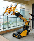 Industrial Grade Electric Vacuum Glass Lifter With Smooth 360 Degree Swivel Handle For Moving Heavy Mirror Panels Without Breaking A Sweat On Any Job Site Or Warehouse Floor operated by a worker lifting glass on a balcony.