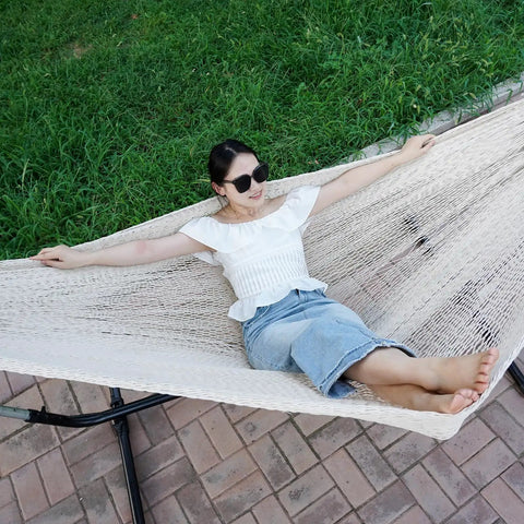 Person relaxing on Mayan Style Handwoven Rope Hammock For Two With Carry Bag Cozy 120 Inch Long By 67 Inch Wide Bed 500 Pound Capacity