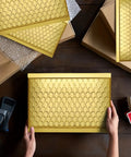 Hands holding a gold bubble mailer from a 6x10 pack, featuring metallic surface and bubble padding for jewelry shipping.