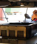 Spill Free 16 Quart Auto Oil Drain Pan With Secure Lid Grab Handle For Easy Fluid Collection During Major Car Maintenance Tasks And Quick Fixes used under a vehicle.