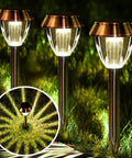 Three solar pathway lights illuminating a garden, part of Solar Pathway Lights 6 Pack Outdoor Waterproof Garden Lighting Stainless Steel Walkway Lamps Cold White 15 Lumen LEDs With Up To 12 Hours Of Ultra Bright Night Illumination
