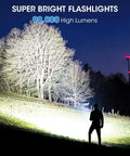Silhouette of person using Two Pack Rechargeable LED Flashlights That Crank Out 990000 Lumens illuminating a field at night