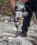 Beast 1200W Electric Rotary Hammer SDS Plus Drill With Swivel Handle in use for concrete drilling on construction site.