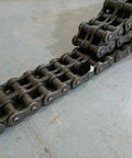 Top Tier 16B-2 Escalator Two Row Main Drive Chain With 25mm Pitch, heavy-duty chain on a grey floor.