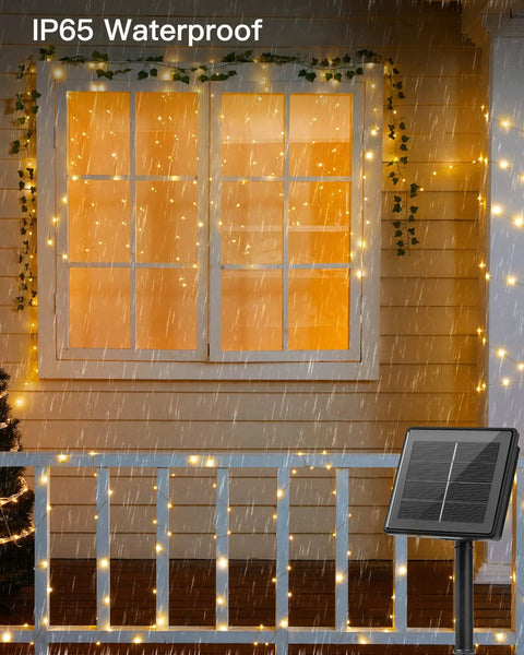 Two Pack Outdoor Solar String Lights 66 Ft Total With 200 LED Warm White Fairy Lights, 8 Lighting Modes, Waterproof shown in rain