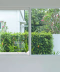 Image of an installed 2 Pack Door Security Bar Heavy Duty Metal Door Stoppers Security Patio Bars 2 In 1 Adjustable Sliding Doors Lock Jammer Stopper For Window Apartment Home Hotel Room White Durable Portable Travel Friendly Lightweight Design With Rubber Base And Tips on a sliding window.