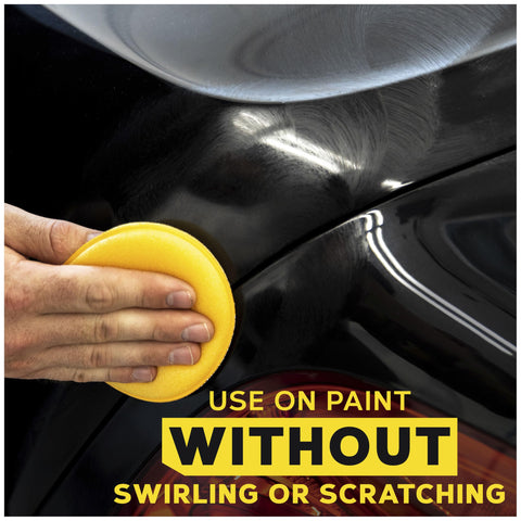 Hand using 4 inch foam applicator pads for car polish on black paint