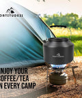Stovetop Camping Kettle 2.2 Liter Teapot for Boiling Water and Tea Brewing sitting on portable camp stove in front of tent