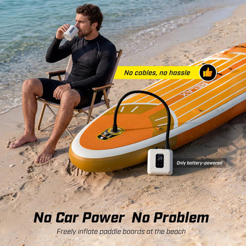 Man sitting on beach with Cordless Electric Paddle Board Pump With Auto Off And Dual Stage Inflation Deflation 7 Nozzles For SUPs