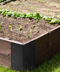 Four Pack Raised Garden Bed Corner Brackets 3 By 3 By 6 Inch Metal L Shaped Corners With Screws installed on wood frame in garden