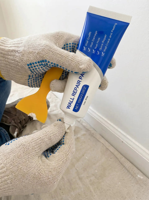 Hands holding Fast Dry Wall Patch Kit With Scraper For Holes And Cracks White Wall Repair Paste Waterproof Heavy Duty