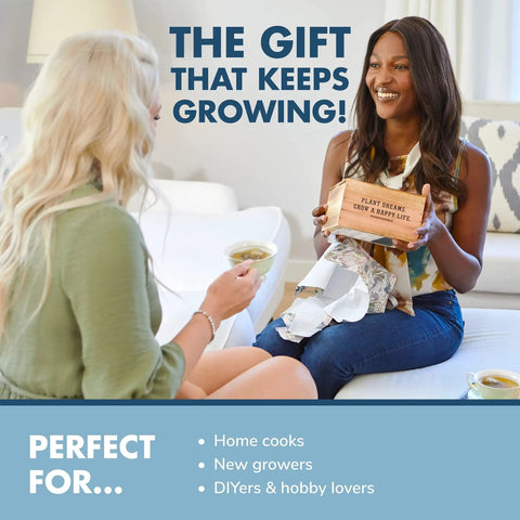 Two women sitting with DIY Indoor Herb Garden Starter Kit, one holding box labeled 'Plant Dreams' and smiling.