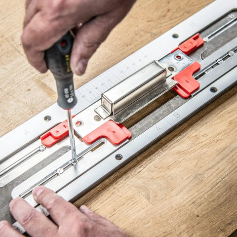 Close-up of No Fuss Adjustable Door Latch And Strike Plate Router Jig featuring precision adjustments and red clamps during setup.