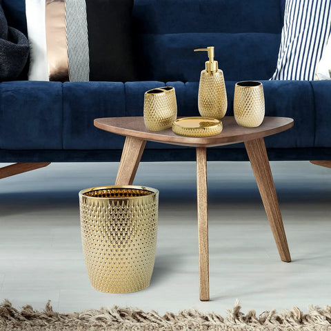 Golden Modern Small Trash Can Wastebasket For Bathrooms Powder Rooms Kitchens And Home Offices Durable Ceramic Round Garbage Container Bin Compact Space Saving Design That Fits Under Sinks Cabinets Or On Counters in a living room setting