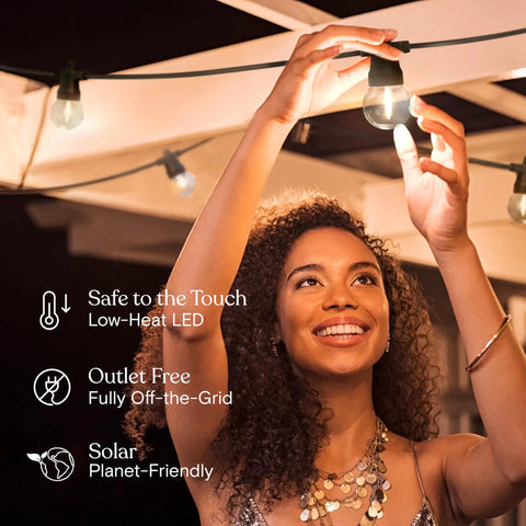 Woman installing Solar Powered Outdoor String Lights 27 Foot Patio Set With Edison Globe LEDs 12 Bulbs 1W Waterproof Soft White
