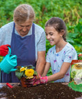 Elderly woman and young girl planting flowers with Ready To Grow Seed Starter Soil Mix 1 Qt for germination and early growth.