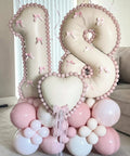 Giant Forty Inch Beige Mylar Foil Number 1 Balloon With Straw For First Birthday And Age Milestone Party Decorations That Are A Straight Up Game Changer, featuring a decorative 18 balloon display with pink accents.