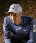 Man wearing Men's Superlite Cap With Perforated Panels For Maximum Airflow And Quick Dry Lightweight Moisture Wicking Workout Hat.