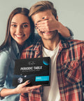 Couple holding Clear Acrylic Periodic Table Display With Wooden Stand Featuring 83 Real Elements Includes 6 Chemistry Formula Reference Cards Cool Classroom Decor And Science Teacher Gift For Any Lab package