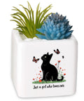 Square white planter with black cat design, inscribed 'Just a girl who loves cats', containing artificial succulents.
