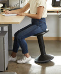 Person sitting on SitWell Wobble Stool With Adjustable Height For Active Seating In Seafoam, promoting core engagement and posture.