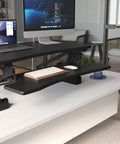 Standing Desk Converter 48 Inch Wide Sit Stand Desk Riser with Dual Gas Spring Handles on desk in office setup